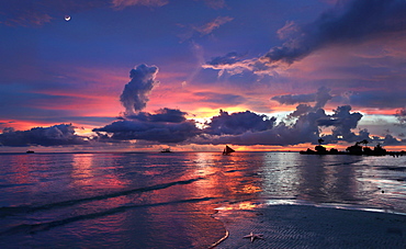 Tranquil scene with beach and sea at sunset with silhouettes of sailboats, Boracay, Aklan, Philippines