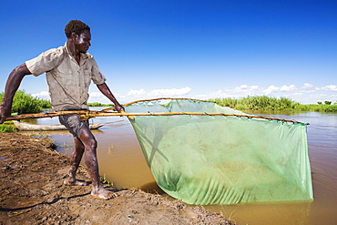 A fisherman catching small fish in the Shire river in Nsanje, Malawi.