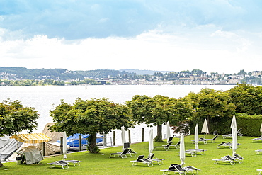 Landscape with LakeÂ ZugÂ , trees and beach chairs,Â Zug, Switzerland