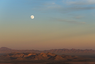 Full moon rising at sunset in desert, Sonora, Mexico