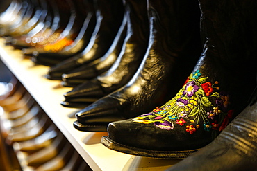 Row of ornate cowboy boots for sale in shop in Nashville, Tennessee, USA