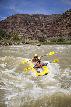 A man and woman paddling an inflatable kayak through rapids on a Green river rafting trip, Desolation/Gray Canyon section, Utah, USA