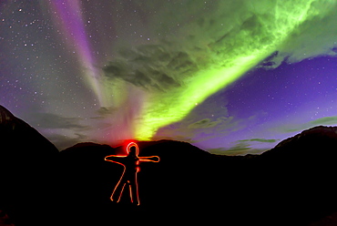 View of light painted human shape under aurora borealis, Narsaq, Greenland