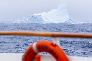 An iceberg seen from a passing ship in a storm 12 miles off the coast of the Westfjords in Iceland