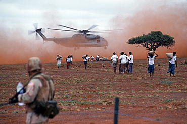 Food is airlifted by a helicopter to a food distribution site, Somalia.