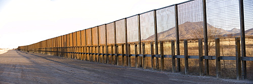 A pedestrian-style fence runs along the Mexican border in Arizona.