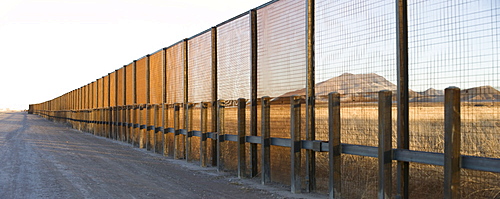 A pedestrian-style fence runs along the Mexican border in Arizona.