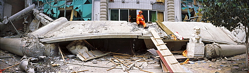 A rescue worker takes a break on top of a collapsed roof May 16 in Beichuan, China. The death toll in China's worst earthquake in 30 years could top 80, 000 according to the government.