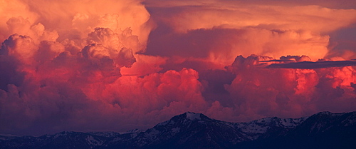 Pink, orange and red thunderheads over Lake Tahoe and the Sierra mountains in the evening