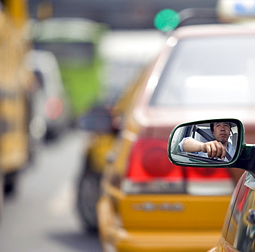 A taxi driver waits in a traffic jam in Beijing,