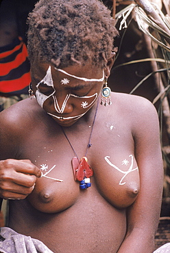 Republic of Congo (formerly Zaire) Ituri Forest. Pygmee girl decorating her breasts.