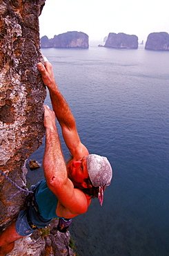 Todd Skinner, top American rock climber, uses small holes and edges in the rock to climb one of the over 3,000 limestone towers and islands in Ha Long Bay, on a route called "Sing Sing", which he rated 5.13c. In the background, other rock spires rise directly from the ocean. Ha Long Bay, a UNESCO World Heritage site, encompasses some 1,600 islands and islets, forming a spectacular seascape of limestone pillars, most of them uninhabited.