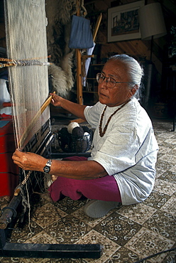 A Navajo weaver weaves a rug in her home near Shiprock, New Mexico on the Navajo Indian Reservation.