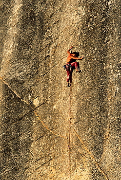 A rock climber scaling the knobby granite walls in Tuolumne Meadows, Yosemite National Park, California