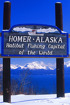 A wooden sign and a view of Kachemak Bay greets visitors at Homer, Alaska. The small Kenai Peninsula town boasts that it is the