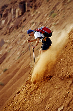Shawn Hanka hiking down the sand dunes in Moab, Utah.