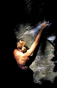 Rock climber Cassandra Riddle climbs out of the shadows while climbing at Carver, Oregon.