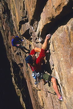 Bruce Miller rock climbing on the route "The Wisdom", rated 5.11b, while his partner Steve Dieckhoff belays, on the Redgarde