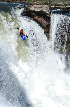 Young man (Scott Feindel) kayaking over Lumbreck Falls near Pincher Creek, southern Alberta, Canada.