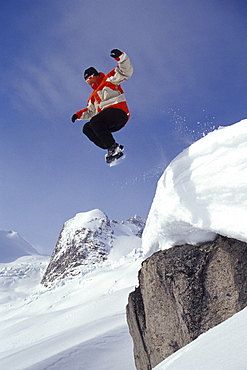 Steve Whelan jumps off cilff into fresh snow in front of the "Hounds Tooth" in Bugaboo Glacier Provincial Park, near Golden, British Columbia, Canada.