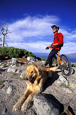 Dan Moses takes a break from mountain biking with his dog Mac and admires the view over Emerald Bay in Lake Tahoe, California.