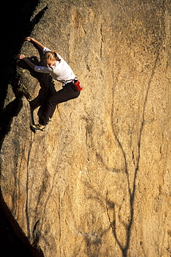 Beth Rodden holds onto the prow of a boulder with aspen shadows visible on its face outside Estes Park, Colorado. Beth Rodden is one of the worlds leading climbers.