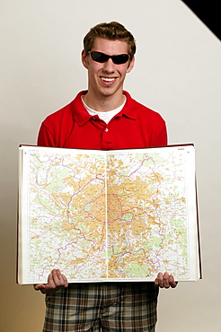 White male college student holding world map.