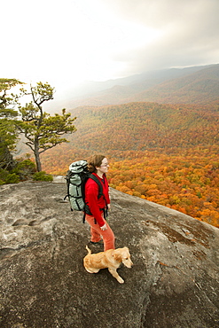 Katie Cavert and Oliver (golden retriever) check out the fall colors from atop Looking Glass Rock in the Pisgah National Forest near Brevard, NC.