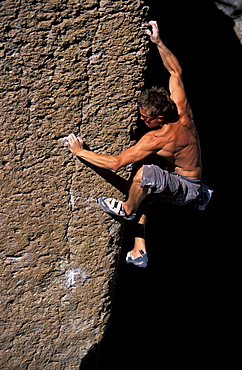 Rock climber Erik Chabala bouldering on Bachar Boulders near Bishop, California in the eastern Sierra Nevada mountains near Hwy 395.