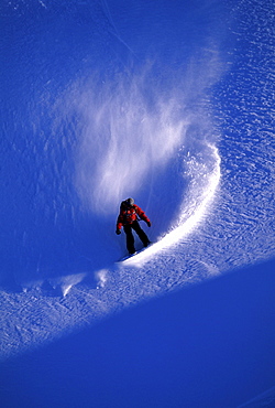 Professional snowboarder Barrett Christy snowboarding in the backcountry on a bluebird powder day, Mt Baker, Washington.