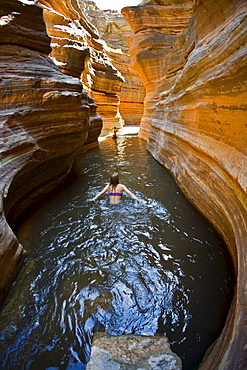 Amy Peterson wading through pool in Deer Creek which is a tributary of the Colorado river, Grand Canyon, Arizona.