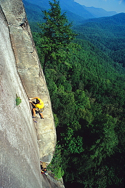 Two men rock climbing on a large granite face in North Carolina.