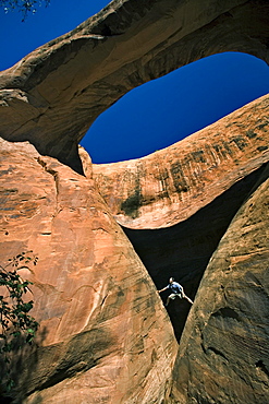 A man below an arch, Moab, Utah.