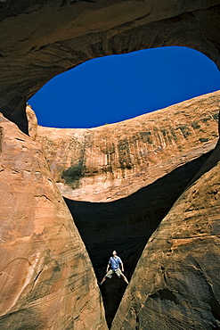 A man below an arch, Moab, Utah.