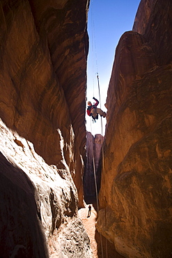 A man rappelling in Arches National Park, Moab, Utah.