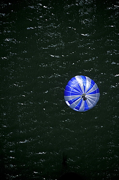 A BASE jumper's open parachute just before landing in a river in Twin Falls, Idaho (High Angle Perspective).