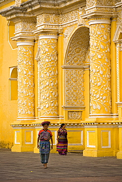 Women walking in front of the church La Merced, Antigua, Guatemala