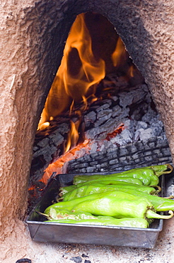 Roasting green chile in a traditional oven in New Mexico