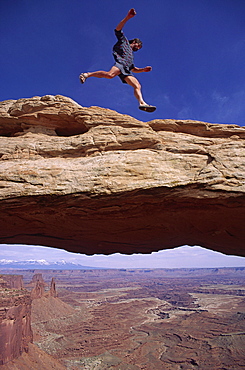 Cliff Leight, a desert adventurer, leaps above Mesa Arch