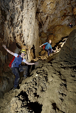 Three cave explorers tackle a steep rubble slope on their way to an underground camp in a cave in the jungle of Mulu called Whit