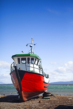 PUERTO NATALES, PATAGONIA, CHILE. A boat on the beach on a sunny day.