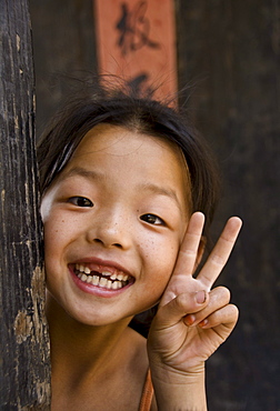 Chinese girl smiling at camera doing the victory sign. Pingyao. Shaanxi Province. China