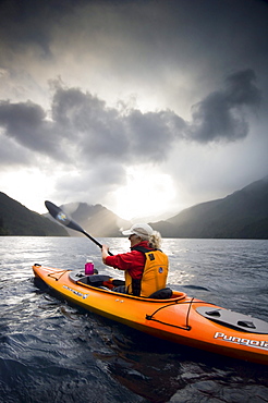 Middle aged woman kayaking on Lake Crescent, Olympic National Park, WA, USA