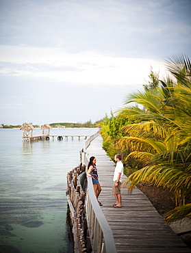 A couple enjoy the boardwalk at a small caye in Belize.