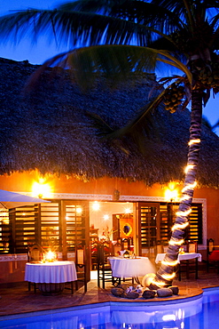 A restaurant is lit up near a pool at a luxury hotel in Belize.