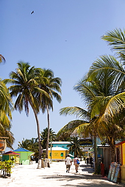 A couple walk down the beach in a small island town in the Caribbean.