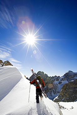 A male skier climbs a ridge near the top Garnet Canyon towards during a stellar day of touring in the Grand Teton National Park, Wyoming.