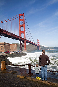 A man and his son gaze at the Golden Gate Bridge near Fort Point in San Francisco. Feb. 2010