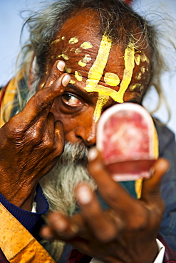 An Indian Sadhu making holy signs on his forhead; Vrindavan, India.