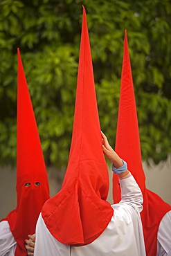 Penitent walk in a street during Easter Holy Week celebrations in Carmona village, Seville province, Andalusia, Spain.